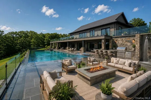 a view of a patio with couches table and chairs with wooden floor and fence