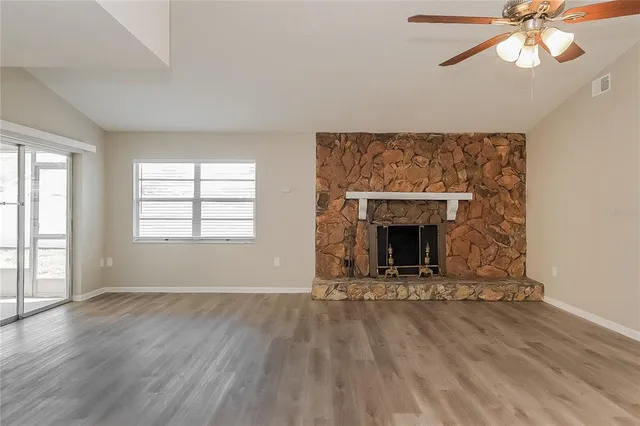 wooden floor fireplace and windows in an empty room