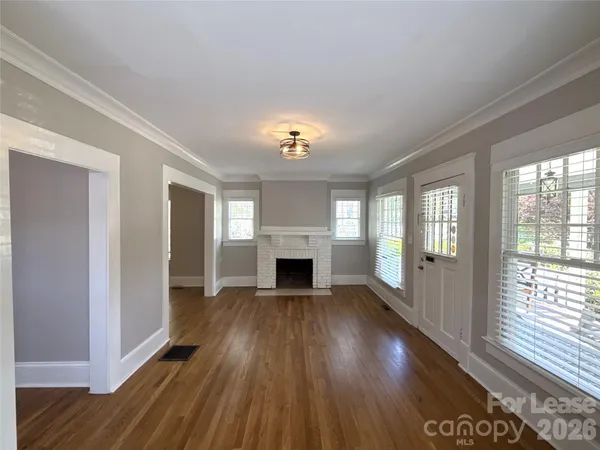 a view of a livingroom with a fireplace wooden floor and window