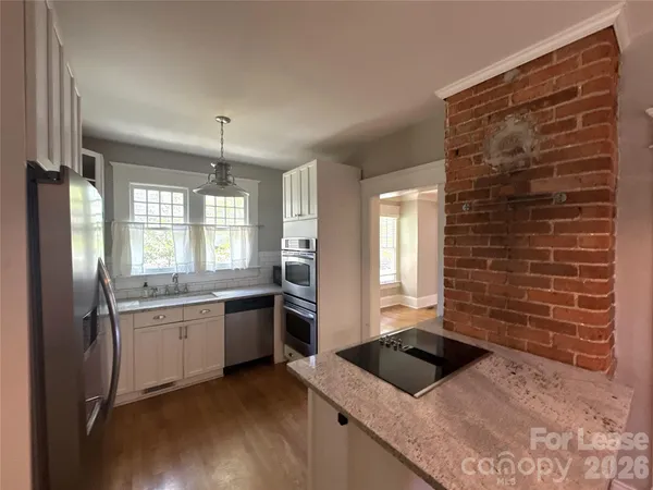 a kitchen with granite countertop a sink stainless steel appliances and cabinets