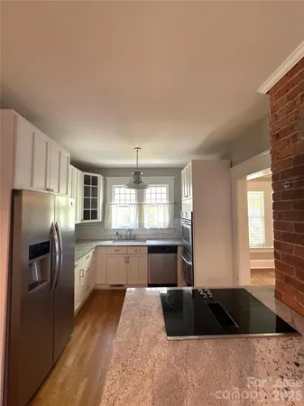 a kitchen with granite countertop a refrigerator and a sink