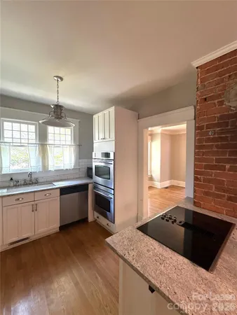 a kitchen with granite countertop a stove and a sink