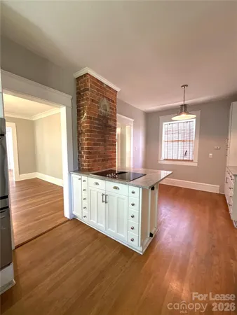 a kitchen with wooden floors and white cabinets