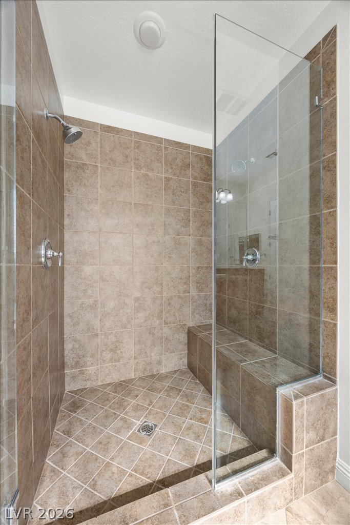 2125 De Rouge Avenue Henderson, NV 89044 - Photo 11 of 96 Step into this spacious walk-in shower, complete with tiled walls and flooring, and a convenient built-in bench.