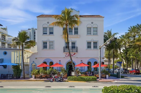 a front view of multi story residential apartment building with yard and sign board