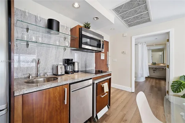 a kitchen with stainless steel appliances granite countertop a sink stove and wooden cabinets