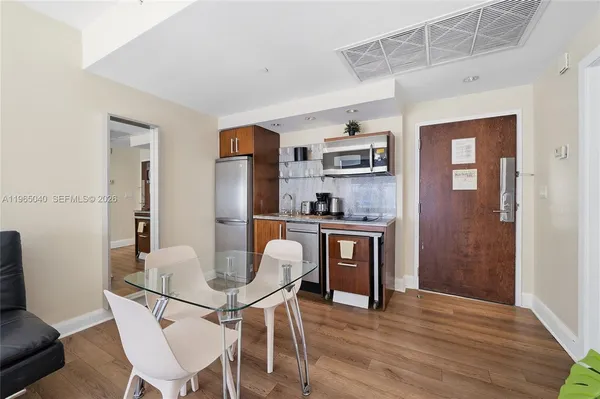 a kitchen with stainless steel appliances granite countertop a dining table and chairs