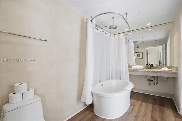 a bathroom with a bathtub a sink and a mirror