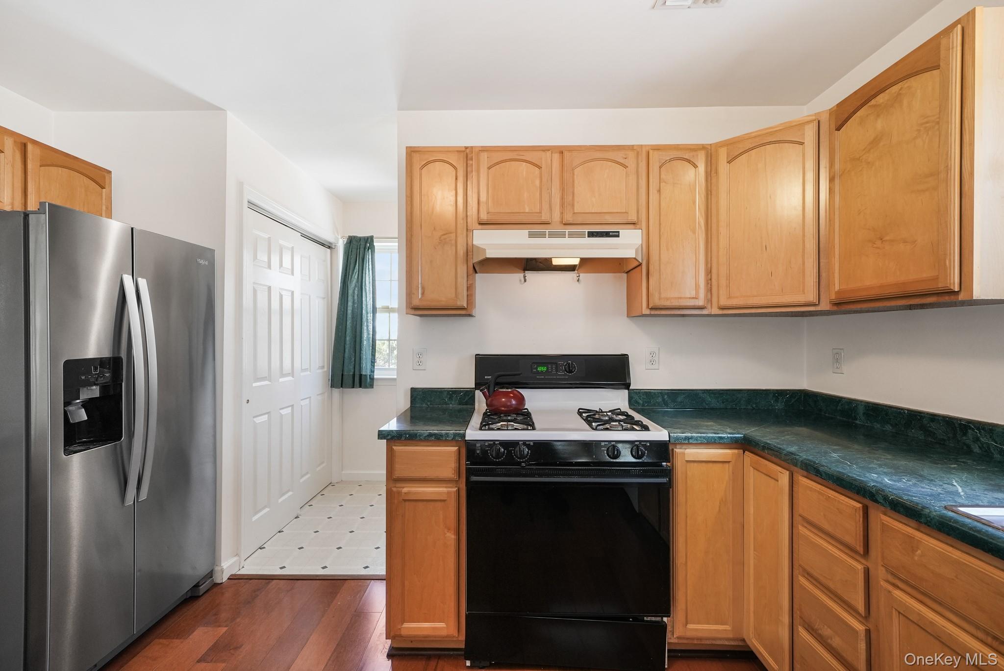 70 Woodland Road Monroe, NY 10950 - Photo 9 of 41 Kitchen featuring stainless steel refrigerator with ice dispenser, gas stove, dark countertops, and dark wood-style floors