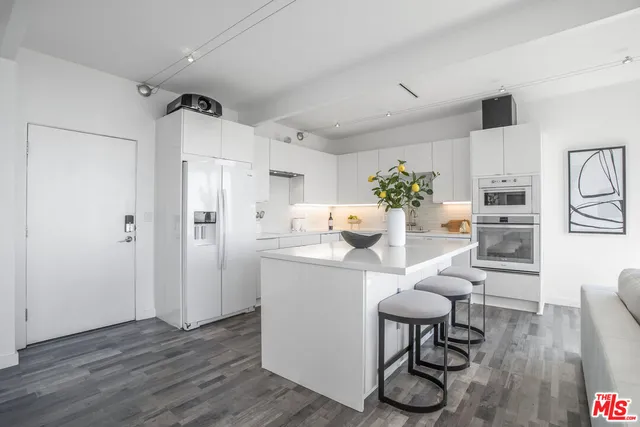 a kitchen with stainless steel appliances kitchen island a table and chairs in it
