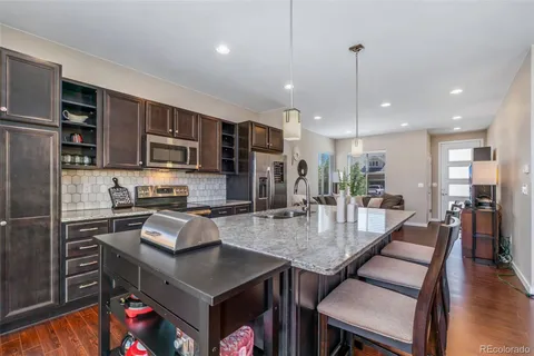 a kitchen with stainless steel appliances granite countertop a stove refrigerator and microwave