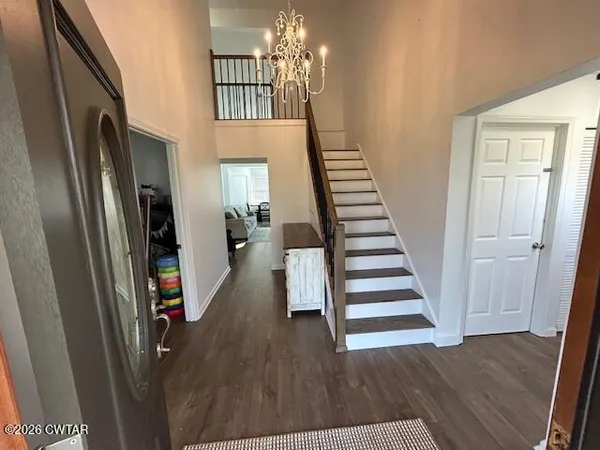 a dining room with furniture a chandelier and kitchen view