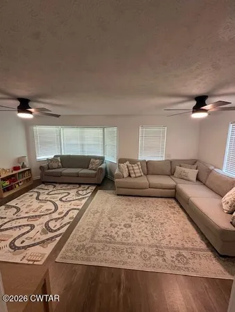 a living room with furniture and a wooden floor