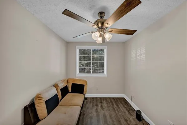 a view of a livingroom with wooden floor and a ceiling fan