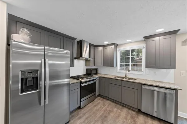 a kitchen with stainless steel appliances granite countertop a refrigerator sink and stove