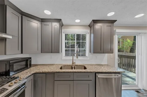 a kitchen with granite countertop a sink and a stove