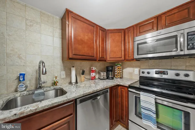 a kitchen with granite countertop a stove sink and cabinets