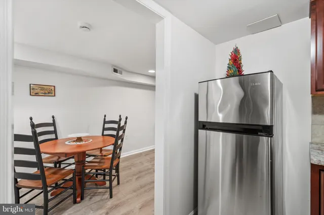 a dining room with furniture and a refrigerator