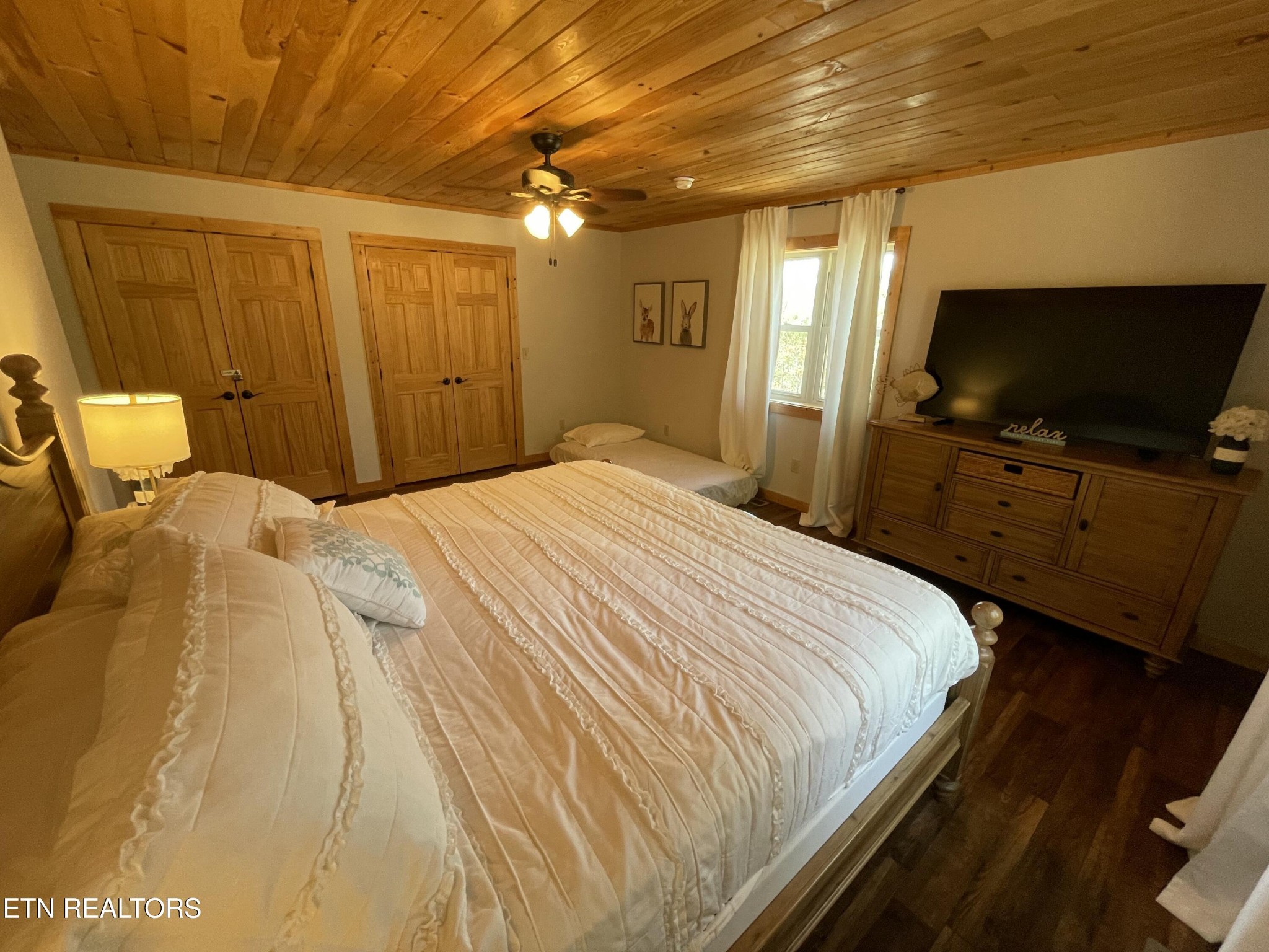 625 Bluff View Road New Tazewell, TN 37825 - Photo 21 of 57 a bedroom with a bed a flat screen tv and a chandelier