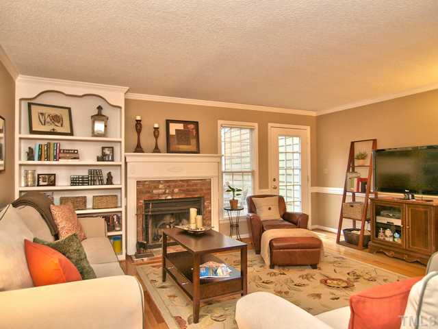 4527 Hershey Court Raleigh, NC 27613 - Photo 2 of 25 Hardwood Floors in the Living Room and Dining Room. Built In Bookcase _ Fireplace with Detailed Mantel, Side Casings and Distressed Brick Surround. Perfect Spot to Warm Your Toes and Sip Hot Chocolate.