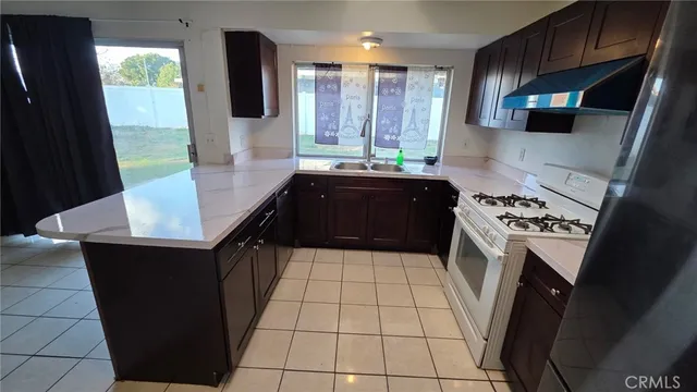a kitchen with a sink a stove top oven a counter top space and cabinets