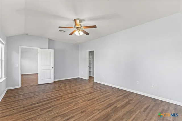 a view of empty room with wooden floor
