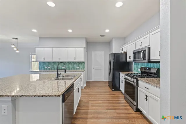 a kitchen with stainless steel appliances granite countertop a sink and stove