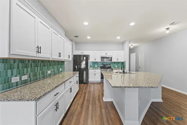 a kitchen with stainless steel appliances granite countertop a refrigerator and a sink
