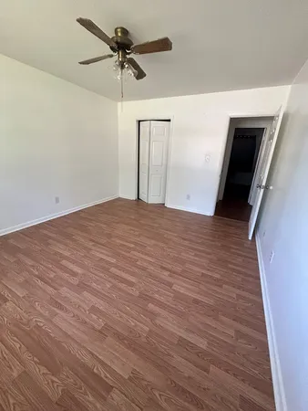 a view of a livingroom with a stove wooden floor and a ceiling fan