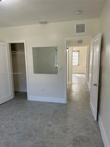 en empty room with window and wooden floor