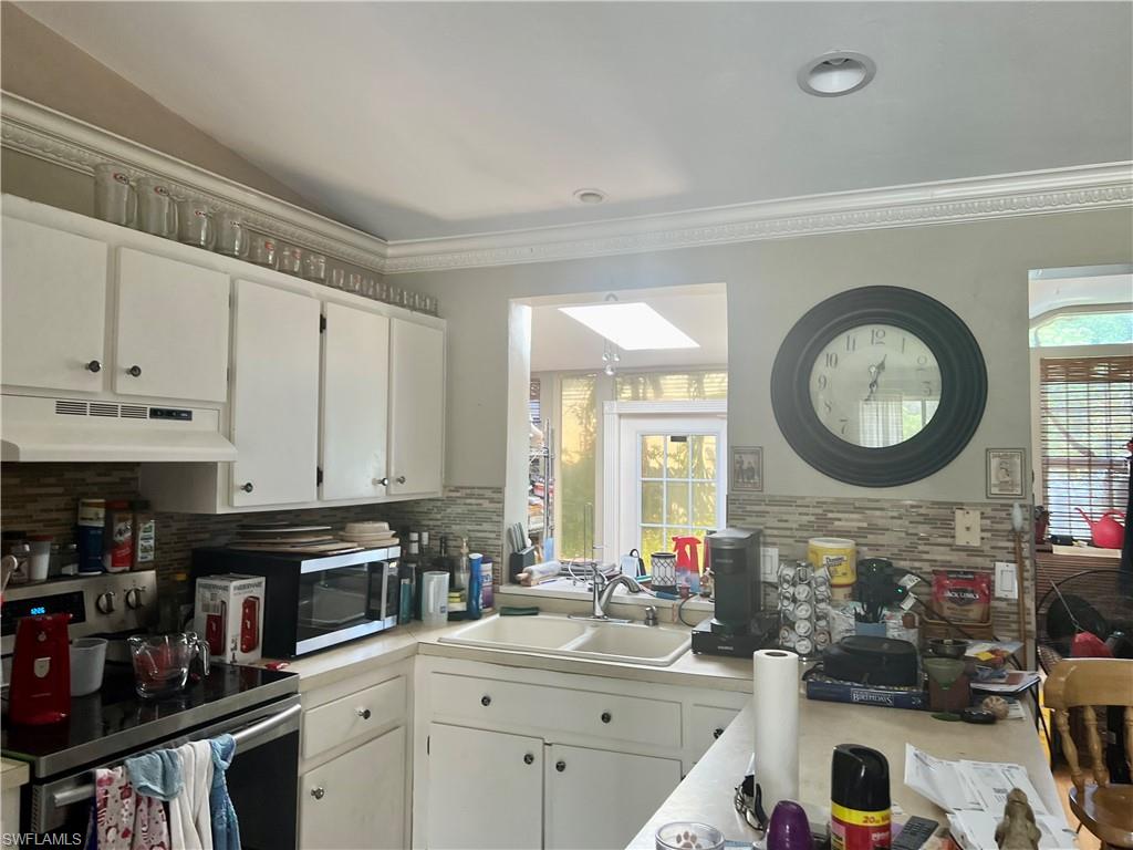 2080 Pelton Avenue Naples, FL 34112 - Photo 30 of 43 a kitchen with a sink a stove top oven and cabinets