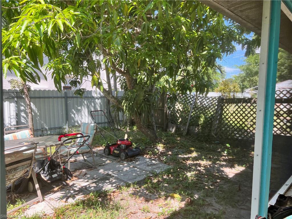 2080 Pelton Avenue Naples, FL 34112 - Photo 43 of 43 a backyard of a house with table and chairs under an umbrella