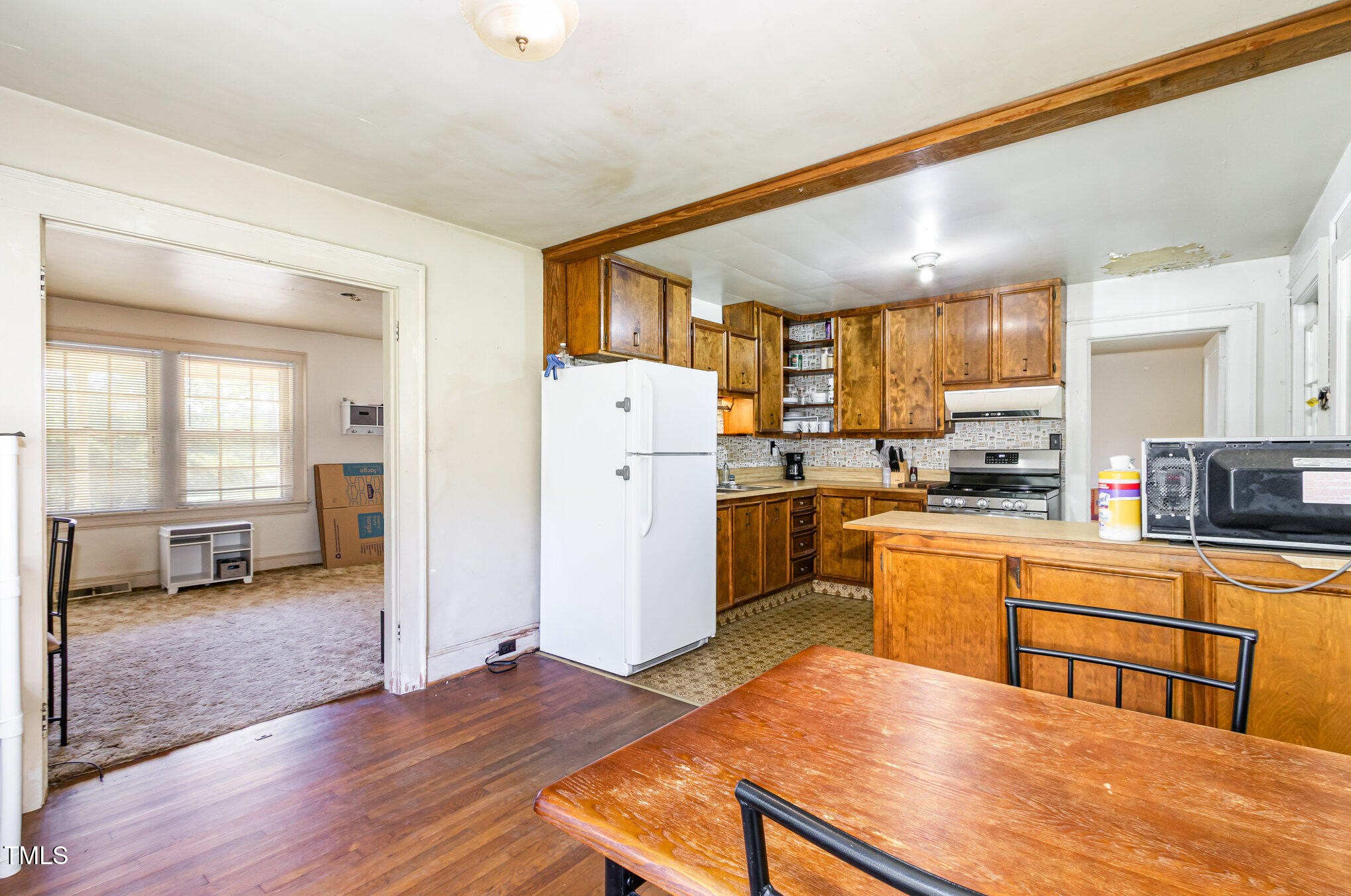 2089 Virgilina Road Roxboro, NC 27573 - Photo 11 of 32 a open kitchen with stainless steel appliances granite countertop a refrigerator a stove and a sink with wooden floor