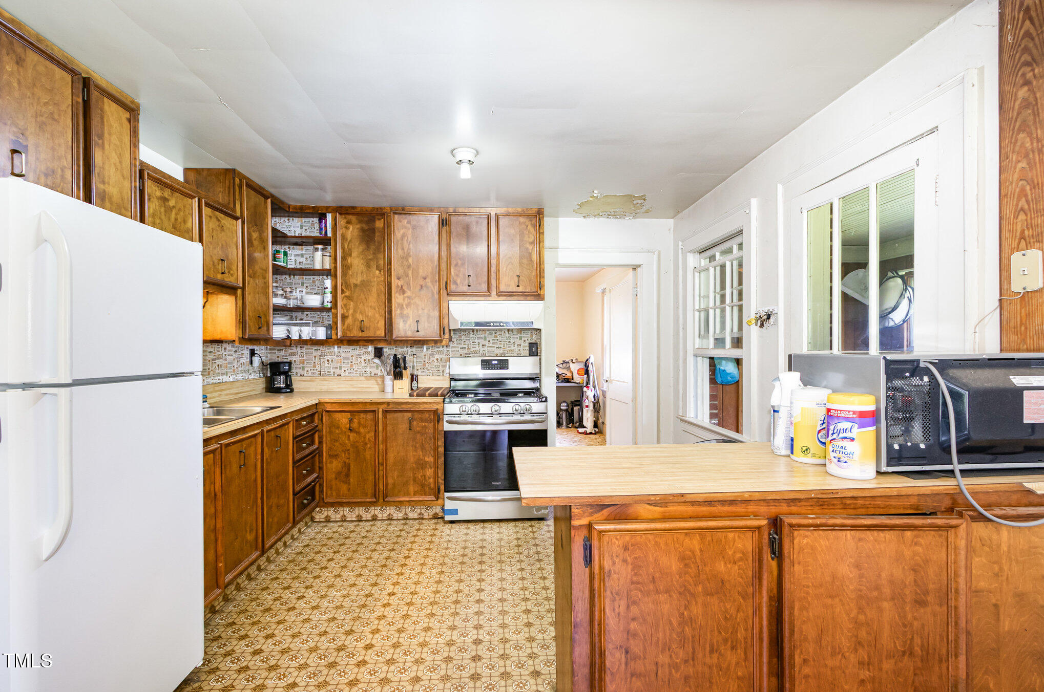 2089 Virgilina Road Roxboro, NC 27573 - Photo 12 of 32 a kitchen with a refrigerator a stove top oven and a large window