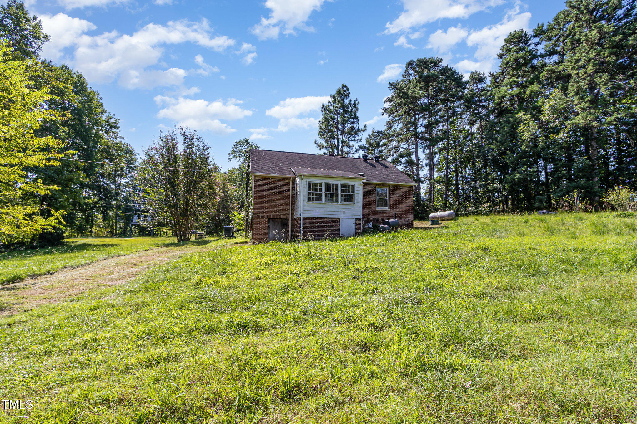 2089 Virgilina Road Roxboro, NC 27573 - Photo 29 of 32 a view of a house with a big yard and large trees