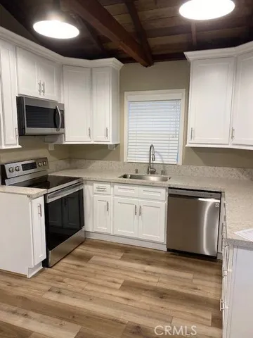 a kitchen with granite countertop white cabinets and white stainless steel appliances