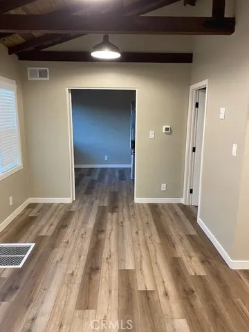a view of a livingroom with wooden floor and staircase
