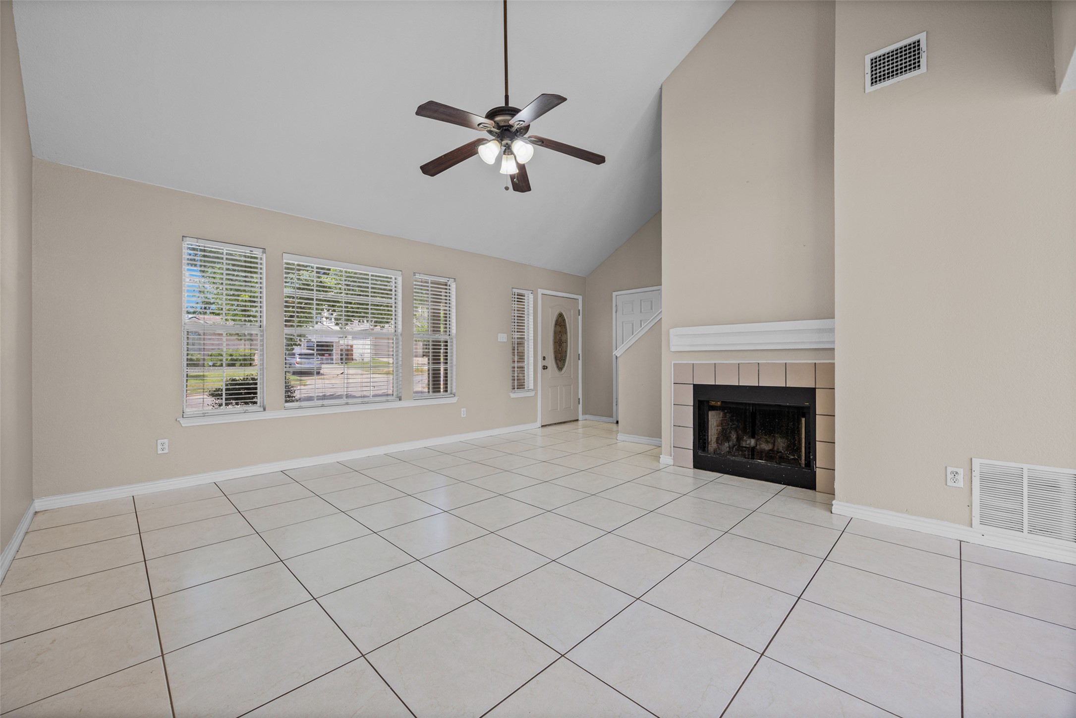 2432 Roundabout Lane Round Rock, TX 78664 - Photo 5 of 22 A spacious living area with soaring vaulted ceilings and a classic fireplace feature.