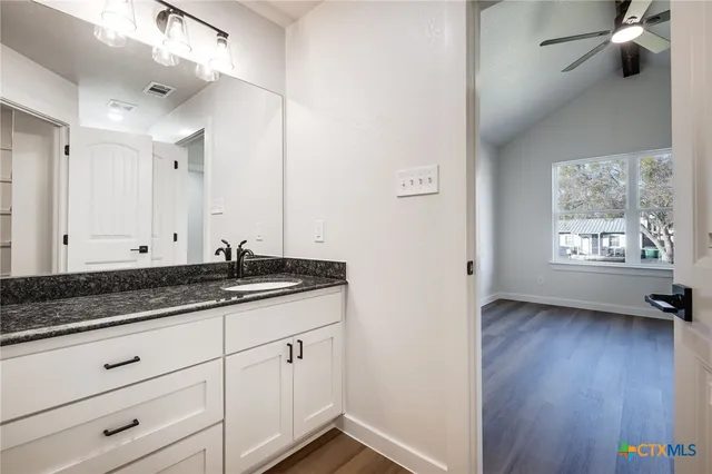 a view of a utility room with wooden floor cabinet and a window