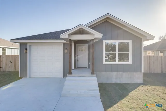 a view of a house with a yard and garage