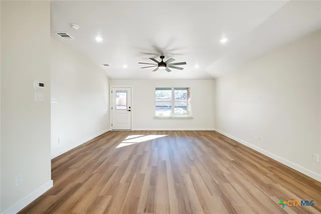 wooden floor in an empty room with a window