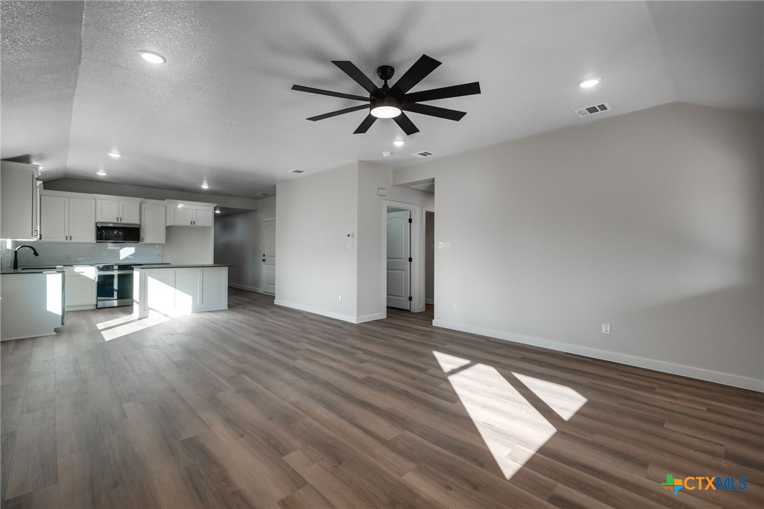 1208 Mill Street Gatesville, TX 76528 - Photo 6 of 28 a view of empty room with wooden floor and ceiling fan