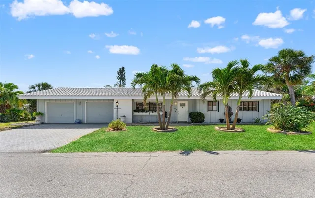 a view of house with yard and tree in front of it