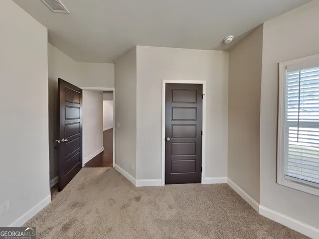 an empty room with windows and closet