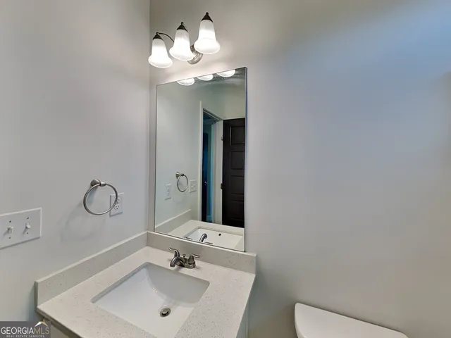 a bathroom with a toilet sink and mirror