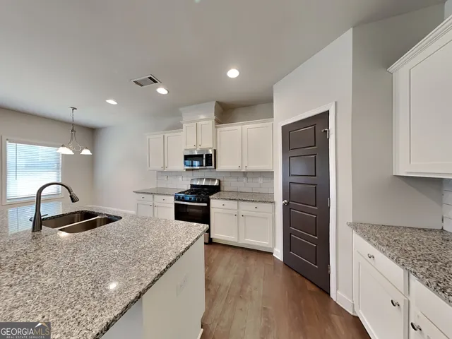 a kitchen with stainless steel appliances granite countertop a sink stove and refrigerator