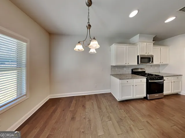 a kitchen with microwave a stove a sink and a window