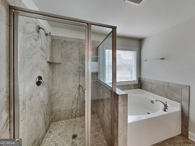 a bathroom with a bathtub and shower