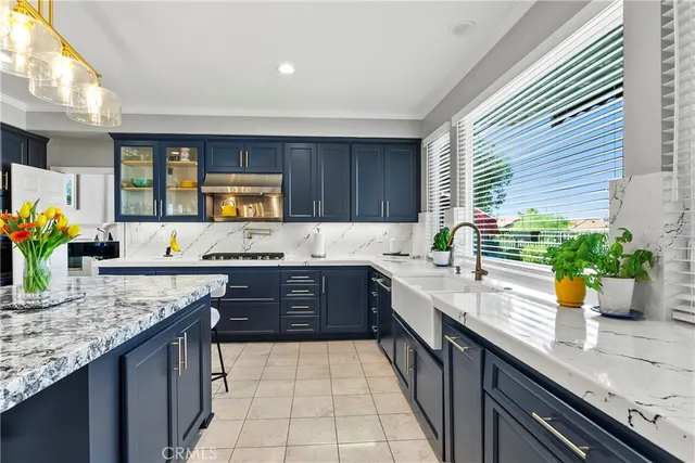 a kitchen with a sink a counter top space cabinets and stainless steel appliances