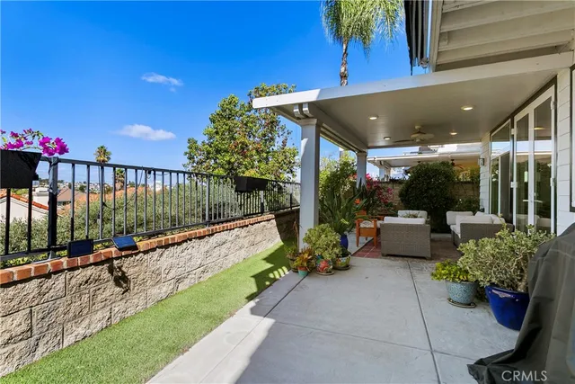 a view of a patio with couches table and chairs and potted plants